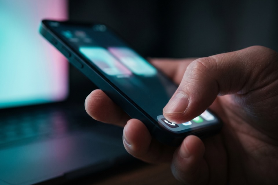 Close-up of a thumb removing a repost on an iPhone