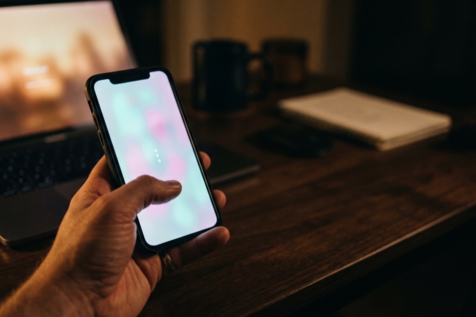 A hand holding a phone deciding how to undo a reshare