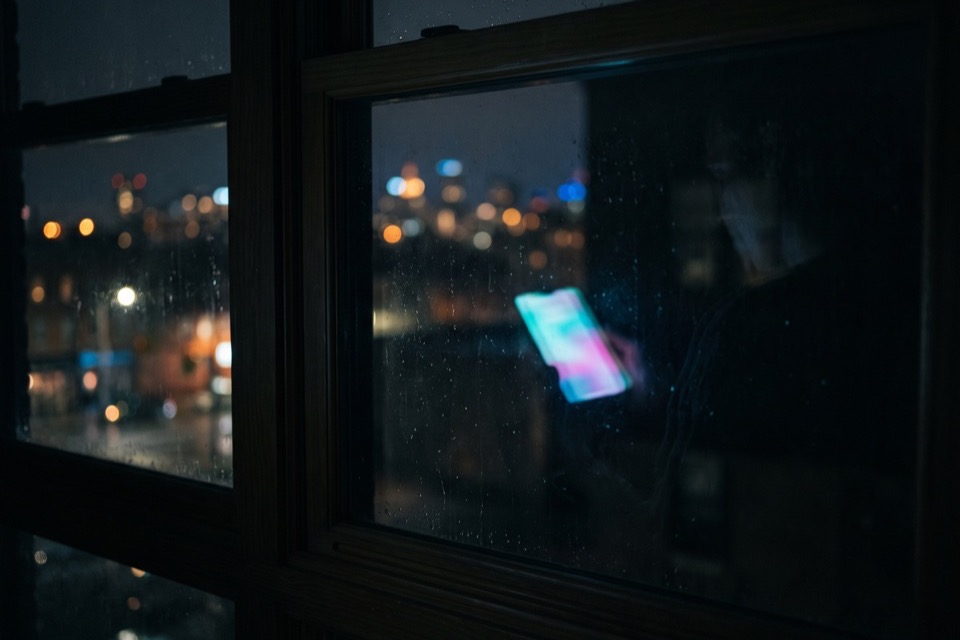 A phone reflected in a night window