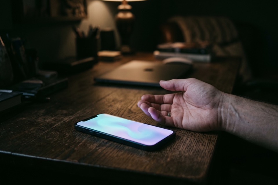 A phone working on its own beside a resting hand